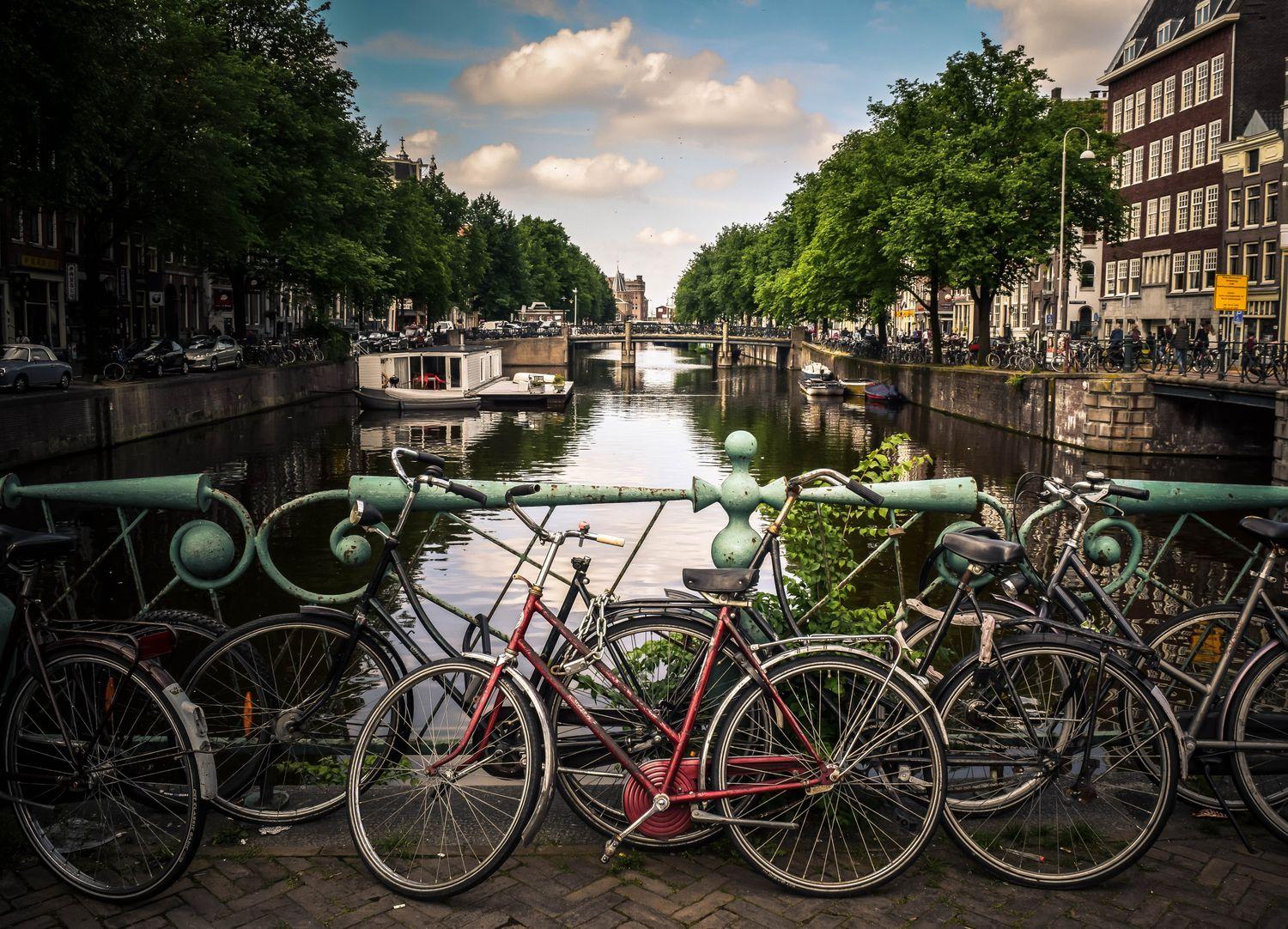 Fahrräder auf einer Brücke über holländischem Hausbootkanal 