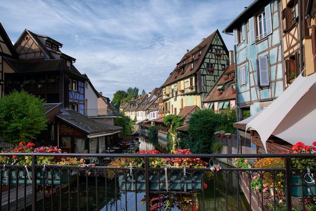 Blick von einer kleinen Brücke auf einen Kanal bei Colmar im Elsass, Fachwerkhäuser und Blumen